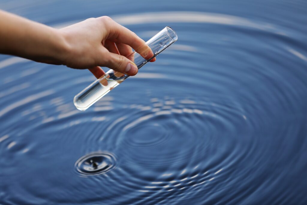 En person som tar ett vattenprov i en sjö